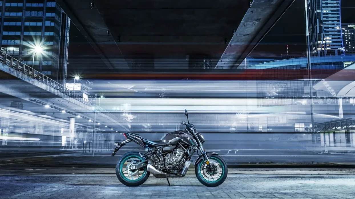 Static image of Yamaha MT-07 2024 in Grey Colourway, side on long shot, long exposure of night neon coloured cityscape