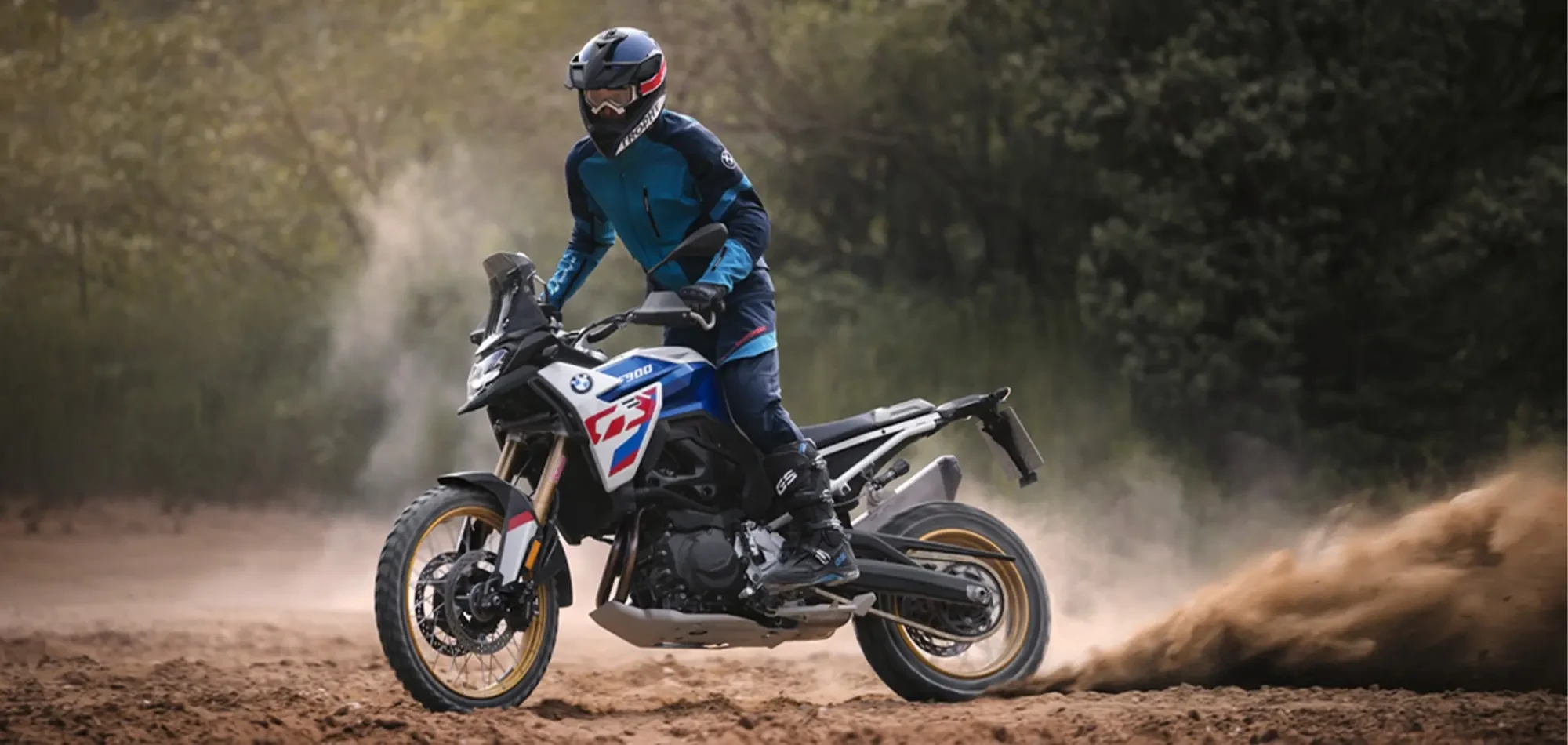 Action image of BMW Motorrad F 900 GS Enduro, available at Brisan Motorcycles Newcastle, crossed up in the dirt with rear wheel spinning