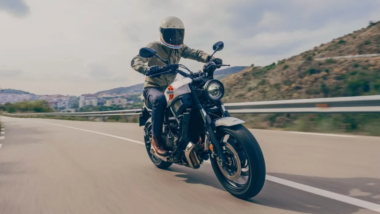 Action image of Yamaha XSR700 in white Colourway, tracking shot in mountains