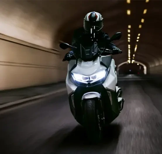 Action image of BMW C 400 GT in Alpine White colourway, head on tracking image through a city tunnel