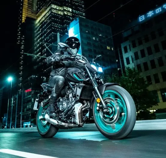 Action image of Yamaha MT-07 2024 in Grey Colourway, front three quarter tracking night neon cityscape