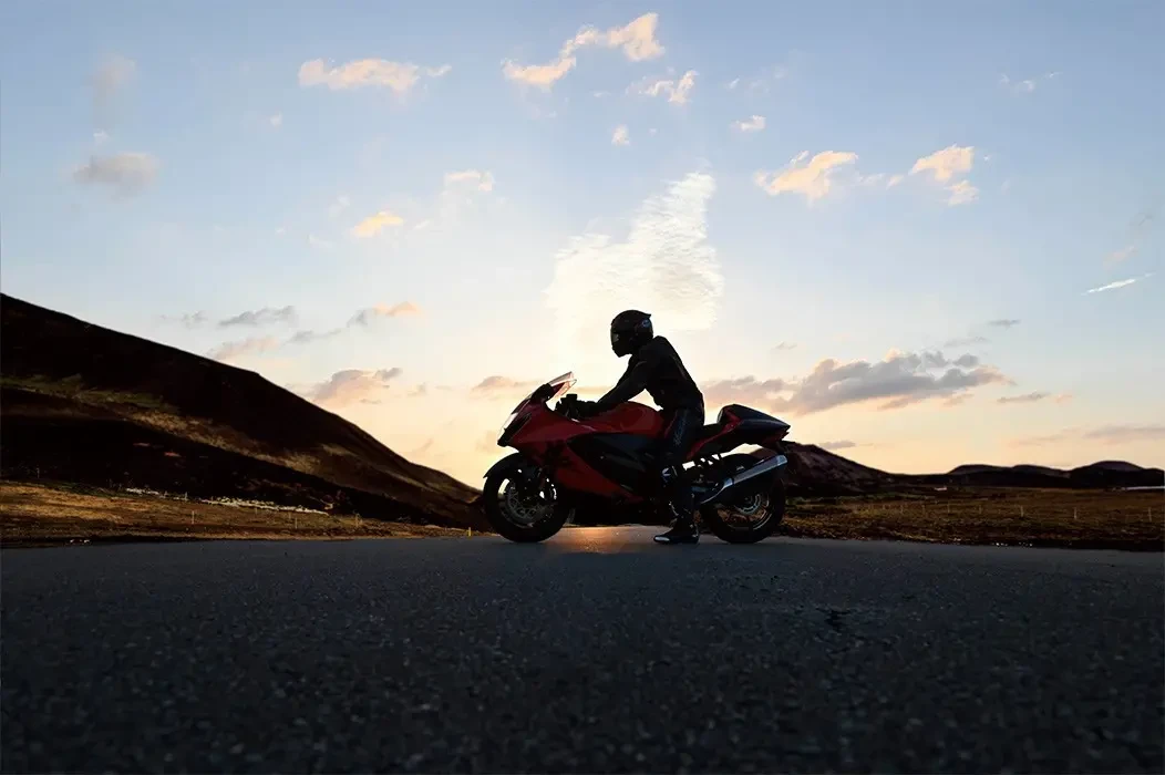 Rider sitting on Hayabusa 25th Anniversary at sunset in middle of road in the mountains