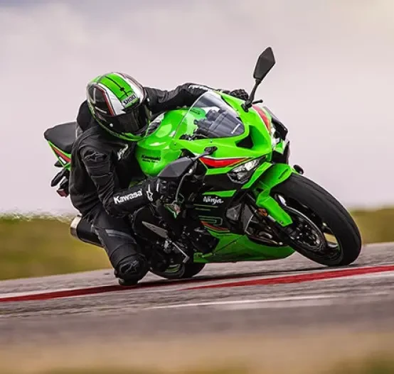 Action image of Kawasaki Ninja ZX-6R in Lime Green colourway, knee down on racetrack