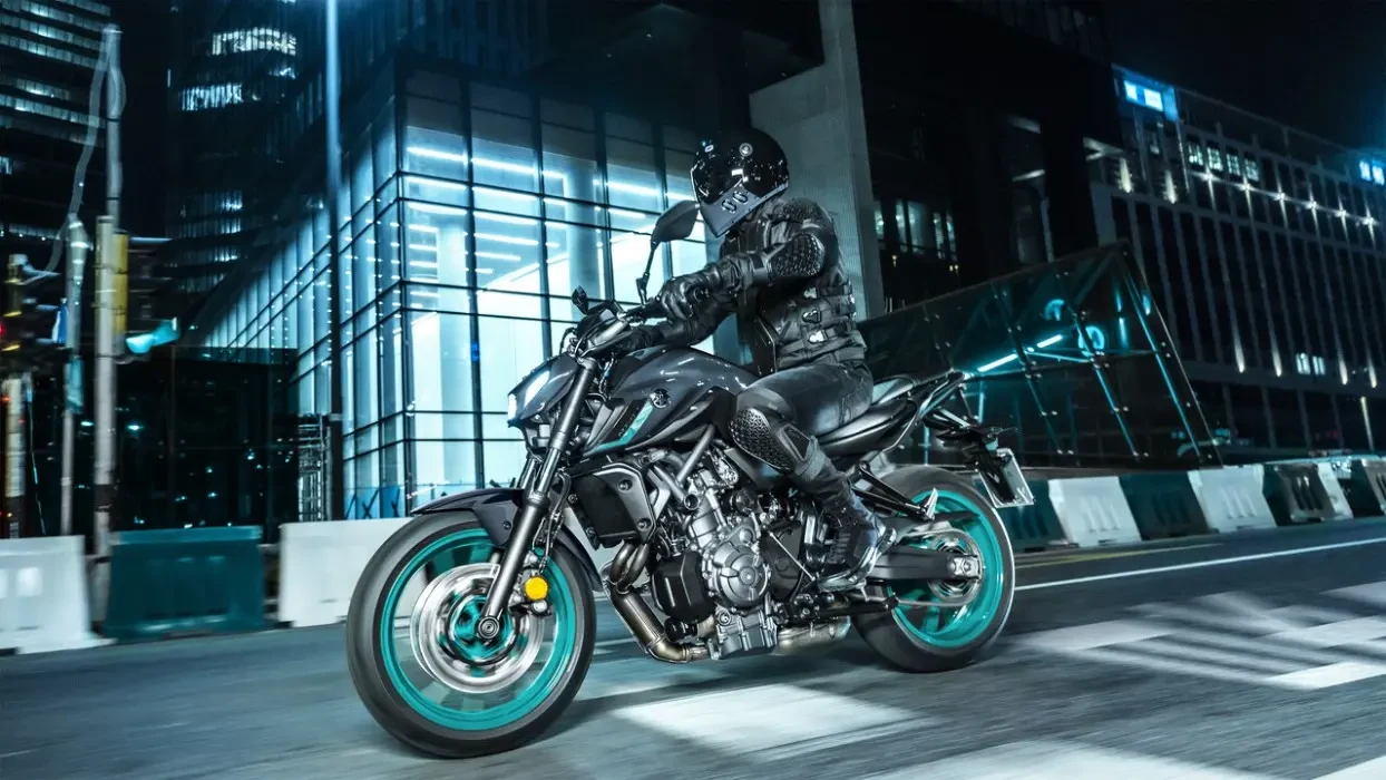 Action image of Yamaha MT-07 2024 in Grey Colourway, side on tracking shot at night in a neon-coloured cityscape
